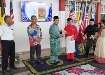 ISMAIL Lasim (tiga dari kiri) melancarkan buku Pendeta Za'ba sempena Perhimpunan Bulanan Jabatan Pendidikan Negeri Sembilan (JPNS) dan Gimik Pelancaran Paparan Wajah Merdeka Anak Noghori di pekarangan JPNS di Seremban hari ini.-UTUSAN/NAZARUDIN SHAHARI.