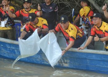 AMINUDDIN Harun (tengah) melepaskan benih udang galah sempena pertandingan Cabaran Sopit Biru Sungai Timun di Jeti Pengkalan Sungai Timun, di Rembau hari ini.-UTUSAN/MOHD. SHAHJEHAN MAAMIN.