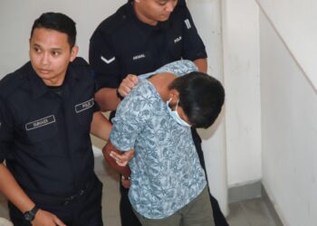 S. Dorairaj dibawa anggota polis bagi menghadapi pertuduhan menyebabkan kematian seorang lelaki warganegara India. - UTUSAN/ISKANDAR ISHAK