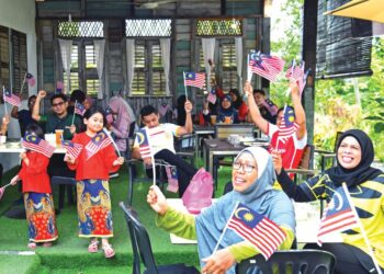 PENGUNJUNG bersama-sama mengibarkan Jalur Gemilang di The Bunker Cafe, Batas Liku di Arau, Perlis sekali gus menyemarakkan sambutan bulan kebangsaan. - UTUSAN/IZLIZAN OTHMAN/pemberita MOHD. HAFIZ ABD. MUTALIB