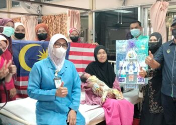 SITI Rohana Samsudin (tengah) memangku bayi lelakinya yang dilahirkan pada sambutan Hari Kebangsaan di Hospital Parit Buntar hari ini. - UTUSAN/WAT KAMAL ABAS