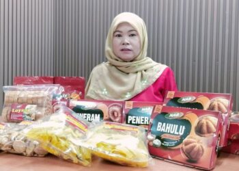 NOR Azizah Amri menunjukkan kuih tradisional baulu dan peneram keluaran NAB Food Industries.
 – UTUSAN/WAT KAMAL ABAS