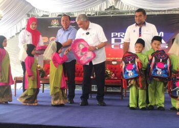AHMAD Zahid Hamidi (tengah) menyerahkan sumbangan kepada pelajar tadika selepas merasmikan Hari Potensi Kemas dan Program Desa Cerdas di Plaza MT-GT Bukit Bunga, Ayer Lanas, Jeli, Kelantan. - UTUSAN/ROSMIZAN RESDI