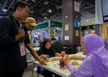 MUHAMMAD Syakir Fitri Sadri (kiri) bertemu orang ramai di Senawang bagi memperkenalkan dirinya sebagai calon Bebas di DUN Paroi.-UTUSAN/AFIFI HAFIZ MOHD. NOR