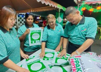 PENYOKONG Pas bukan Islam  di DUN Kota Lama saling berkerjasama menggantung bendera serta menghias markas Pas  di Dataran Cheng Ho,Kota Bharu, Kelantan. UTUSAN/ROSMIZAN RESDI