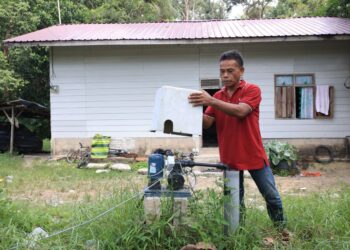 NIK Mustapa Mohd. Bukhari menunjukkan telaga yang menjadi sumber utama bekalan air di Kampung Batu 5 1/2, Kemahang, Tanah Merah, Kelantan.-UTUSAN/KAMARUL BISMI KAMARUZAMAN