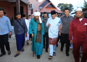 ANWAR Ibrahim (tiga kanan) berbual dengan Muhaizat Muhammad sambil berjalan semasa menziarahi Madrasah Ribat Al-Musthofa, Kampung Bagan Bawah, Pulai Condong, Machang, Kelantan hari ini-UTUSAN/KAMARUL BISMI KAMARUZAMAN.