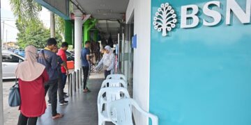 SEBAHAGIAN penerima Sumbangan Tunai Rahmah (STR) beratur untuk mengambil bantuan tersebut di Bank Simpanan Nasional (BSN) .