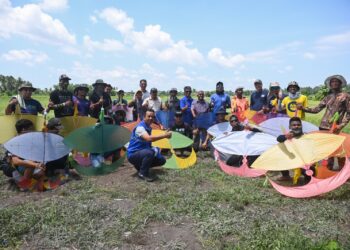 BAZLAN Abd. Rahman bergambar bersama komuniti setempat dalam satu pertandingan wau di Kampung Bukit Cempaka, Batu Rakit, Kuala Nerus. – UTUSAN/PUQTRA HAIRRY ROSLI