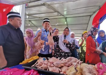FUZIAH Salleh (empat dari kiri) membuat pengumuman harga ayam pada Program Jelajah Jualan Rahmah peringkat negeri Terengganu di Kuala Ibai, Kuala Terengganu, hari ini. - UTUSAN/KAMALIZA KAMARUDDIN