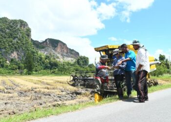 AZIZAN Mahmud (tiga dari kanan) menunjukkan buku yang merekodkan harga padi baharu kepada para pesawah lain selepas kerajaan mengumumkan peningkatan harga subsidi padi di Kampung Bawah Bukit, Chuping, Perlis semalam.- UTUSAN/IZLIZAN OTHMAN