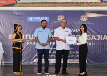 PHILIP Benedict Lasimbang menyampaikan Bantuan Awal Pengajian YBR kepada salah seorang penerima di Sekolah Menengah Kebangsaan (SMK) Bahang, Penampang, Sabah. - IHSAN YBR