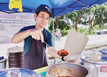 NAZRIN Shah Jamaludin menyediakan nasi bungkus untuk pelanggannya di gerainya di Taman Tasik, Ayer Keroh, Melaka. - UTUSAN/MUHAMMAD SHAHIZAM TAZALI