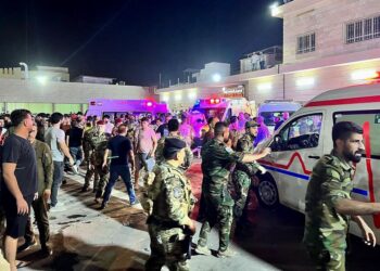 PASUKAN penyelamat berkumpul sekitar ambulans di luar hospital Hamdaniyah di al-Hamdaniyah, Iraq. - AFP