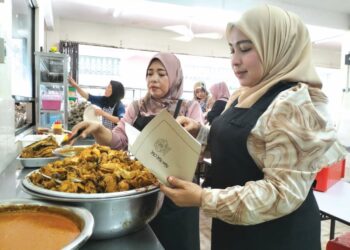 PEKERJA Kak Chik Nasi Berlauk membungkus nasi untuk dijual kepada pelanggan mereka di Kampung Berangan Tumpat, Kelantan. - UTUSAN/ROHANA ISMAIL