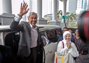 Ahmad Zahid Hamidi mengangkat tangan selepas dilepas tanpa bebas daripada 47 pertuduhan rasuah, pecah amanah dan pengubahan wang haram di Mahkamah Tinggi Kuala Lumpur, semalam. – UTUSAN/
M FIRDAUS M JOHARI