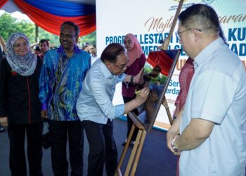 ANWAR Ibrahim  menandatangani plak simbolik perasmian Program Lestari Niaga @ Kuala Lumpur di Medan Selera Madani Kompleks Tun Sambanthan, semalam.
Turut sama, Menteri Sumber Manusia, V. Sivakumar (dua kiri). -UTUSAN/FARIZ RUSADIO