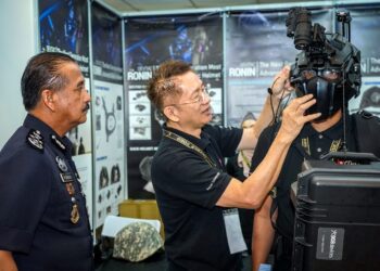 Razarudin Husain  mendengar penjelasan  Ketua Pegawai Eksekutif Xspec Technology Sdn. Bhd., Sugito Wibawa mengenai helmet balistik Devtac Ronin ketika melawat ruang pameran selepas Majlis Perasmian Penutup Simposium Sains Forensik Kebangsaan 2023 di Maktab Polis Diraja Malaysia (PDRM), Cheras, semalam. -UTUSAN/MUHAMAD IQBAL ROSLI