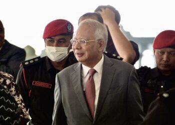 NAJIB Tun Razak diiringi pegawai penjara tiba di Mahkamah Tinggi Kuala Lumpur bagi perbicaraan kes berkaitan 1Malaysia Development Berhad (1MDB). - UTUSAN/SYAKIR RADIN