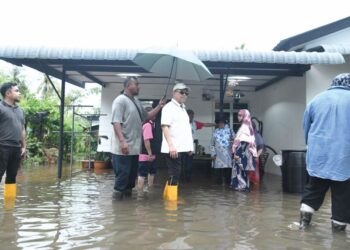 SHAHIDAN Kassim meninjau salah sebuah rumah mangsa yang terjejas akibat banjir di Kampung Kubang Gajah, Arau, Perlis, semalam.- UTUSAN/IZLIZAN OTHMAN