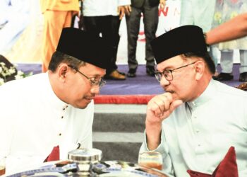 Anwar Ibrahim berbual dengan Suhaizan Kayat pada Kenduri Rakyat di Parlimen Pulai baru-baru ini.