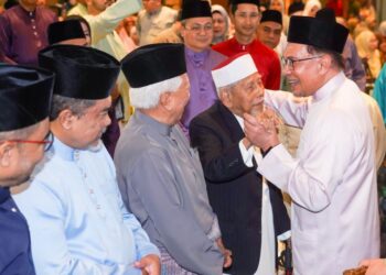 Datuk Seri Anwar Ibrahim menyantuni mantan Pengarah Urusan Tabung Haji (1964-1965), Tan Sri Hanafiah Hussain pada Majlis Pelancaran Sambutan Ulang Tahun ke-60 Lembaga Tabung Haji di Menara Tabung Haji  di Jalan Tun Razak, Kuala Lumpur semalam. -UTUSAN/SHIDDIEQIIN ZON