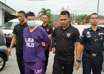 SUSPEK yang memakai baju lokap dibawa oleh polis untuk mendapatkan perintah tahanan reman di Mahkamah Majistret Tanah Merah, Kelantan hari ini-UTUSAN/ROHANA ISMAIL