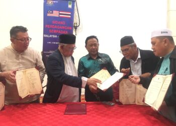 MOHD. Azmi Abdul Hamid (tiga dari kiri )menunjukkan dokumen MoU yang ditandatangani selepas Sidang Perdagangan Sempadan Malaysia - Thailand di Hotel Grand Riverview, Kota Bharu, Kelantan. UTUSAN/ROSMIZAN RESDI