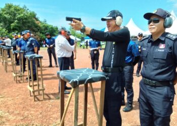 MUHAMAD Zaki Harun (kiri) menunjukkan kemahiran menembak sebagai gimik Perasmian Majlis Penutup Kursus Tempur Jarak Dekat di Lapang Sasar Bukit Pak Junoh, Rantau Panjang, Kelantan hari ini-UTUSAN/ROHANA MOHD. NAWI.