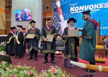 ZAINAB Othman (dua dari kanan) menyerahkan skrol diploma kepada seorang graduan pada Majlis Konvokesyen Politeknik Kota Bharu, Kelantan hari ini. UTUSAN/MUSTAQIM MOHAMED