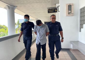 TERTUDUH diiring keluar anggota polis selepas mengaku tidak bersalah di Mahkamah Sesyen, Ayer Keroh, Melaka atas pertuduhan mendatangkan kecederaan.