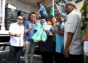 FUZIAH Salleh (tengah) menunjukkan ayam berharga RM1 seekor yang dijual dalam Program Jualan Rahmah Bergerak (PJRB) peringkat negeri Perak di Gopeng hari ini. - UTUSAN/MUHAMAD NAZREEN SYAH MUSTHAFA