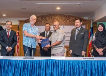 ROSALAM Sabartly, Hairulazim Mahmud dan Roland Oliver Niun menandatangani dokumen perjanjian penyelidikan mengenai populasi gajah Borneo di UMS, Kota Kinabalu, Sabah, baru-baru ini.