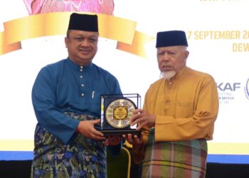 TUANKU Syed Faizuddin Putra Jamalullail menyampaikan anugerah kepada Pengerusi Masjid As-Syakirin, Oran, Ya Ali Dahaman yang diistyharkan sebagai pemenang pengerusi masjid terbaik sempena Konvesyen Masjid-Masjid Negeri Perlis di Dewan Warisan, Kangar, Perlis semalam.-UTUSAN