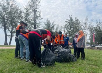 MAZURA Ngah Abd. Manan (kanan) memerhatikan seramai 12 pesalah yang menjalani perintah khidmat masyarakat secara bergotong-royong di Pantai Batu Buruk, Kuala Terengganu, hari ini. - UTUSAN/TENGKU DANISH BAHRI TENGKU YUSOFF