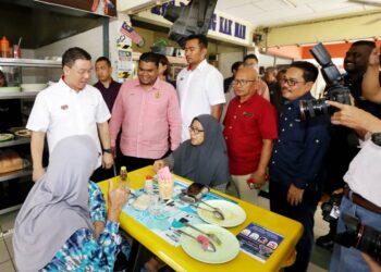 NGA Kor Ming (kiri) beramah mesra dengan pelanggan Medan Selera Taman Perpaduan pada Program Sentuhan Kasih KPKT Parlimen Tambun di Ipoh hari ini. - UTUSAN/MUHAMAD NAZREEN SYAH MUSTHAFA