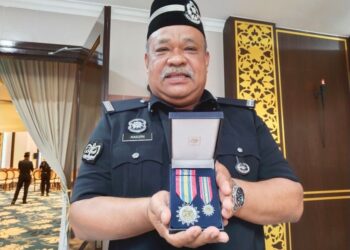 NAZRI Md. Noor menunjukkan pingat yang diterimanya pada Majlis Istiadat Penganugerahan PJPN di Seri Negeri, Ayer Keroh, Melaka. - UTUSAN/MUHAMMAD SHAHIZAM TAZALI