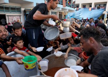 KANAK-KANAK Palestin menerima makanan di sebuah sekolah di Rafah, selatan Semenanjung Gaza. - AFP