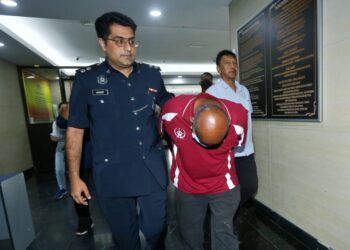 R. RAVINDREN (kanan) ketika didakwa di Mahkamah Majistret Ipoh hari ini atas tuduhan membunuh seorang pengawal keselamatan di sebuah sekolah di Bandar Seri Botani di Ipoh Jumaat lalu. - UTUSAN/MUHAMAD NAZREEN SYAH MUSTHAFA