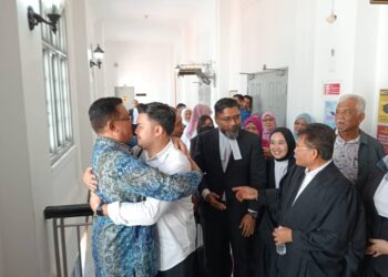 ABDUL LATIF BANDI (kiri) memeluk anaknya, Ahmad Fauzan di luar mahkamah selepas kekal dilepaskan dan dibebaskan oleh Mahkamah Tinggi, Johor Bahru daripada pertuduhan rasuah dan pengubahan wang haram.