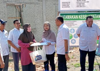 MOHD. JAFNI MD. SHUKOR (dua dari kanan) melawat pembinaan RKJ dan menyerahkan sijil pemilikan rumah kepada penerima di daerah Kulai.