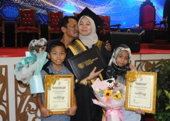 SITI ASYRIYAH MOHD. SALIHIN diberi ciuman tahniah oleh suaminya, Zakaria Abdullah bersama anak mereka, Adam Zikry dan Aishatul Zara pada Majlis Konvokesyen KPYPJ Ke-24 di Dewan Besar, KYPJ, Kota Tinggi.