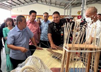 AMINUDDIN Harun (kiri) melihat produk kraftangan yang dihasilkan penghuni penjara selepas beliau merasmikan Program MyPride Fair Peringkat Zon Tengah, Jabatan Penjara Malaysia di sebuah pasar raya di Seremban 2, Seremban hari ini.-UTUSAN/ZAKKINA WATI AHMAD TARMIZI.