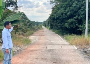 SHUKOR Atan menunjukkan jalan masuk ke Naning Resort di Muar, Johor yang tidak berturap.