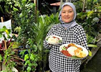 RINA Emi Ibrahim menunjukkan menu yang dijual dan disediakan di Cerita Pokok Nursery Cafe, Batu 6, Jalan Jelebu, Seremban, Negeri Sembilan. - UTUSAN/ZAKKINA WATI AHMAD TARMIZI