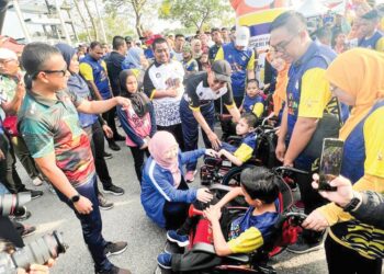 FADHLINA Sidek (duduk) beramah mesra dengan seorang peserta semasa sambutan Hari Sukan Negara Peringkat Negeri Perlis di Kompleks Sukan Tuanku Syed Putra, Kangar, Perlis, semalam. - MINGGUAN/ASYRAF MUHAMMAD