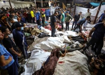 Orang ramai melihat sebahagian daripada mayat rakyat Palestin yang terkorban akibat serangan Israel ke atas  Hospital Ahli Arab di tengah Gaza  baru-baru ini. - AFP