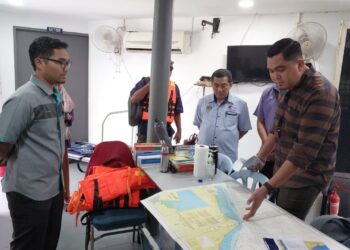 MUHAMAD AKMAL Saleh (kanan) mendengar taklimat daripada pegawai Jabatan Perikanan negeri di Jeti Perlindungan Sumber, Banda Hilir, Melaka. - UTUSAN/MUHAMMAD SHAHIZAM TAZALI