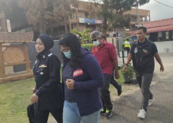 S. Krishna Veni (dua dari kiri) dan abangnya, S. Pojana Rajan (tiga dari kiri) diiringi polis untuk dihadapkan ke Mahkamah Majistret Tampin hari ini bagi didakwa atas pertuduhan membantu memberi pinjam wang tanpa lesen di sekitar daerah Tampin bulan lalu.-UTUSAN/NOR AINNA HAMZAH