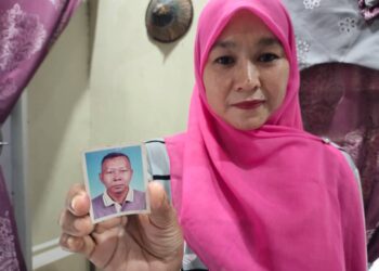 SITI Sazila Shamsudin menunjukkan gambar bapanya, Shamsudin Jusoh ketika sihat bagi tujuan mencari adik-beradik bapanya itu yang terpisah sekian lama.-UTUSAN/NOR AINNA HAMZAH.